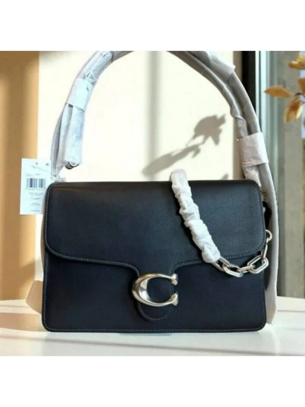 Coach's black Tabby shoulder bag with a "C" shaped metal clasp and chain